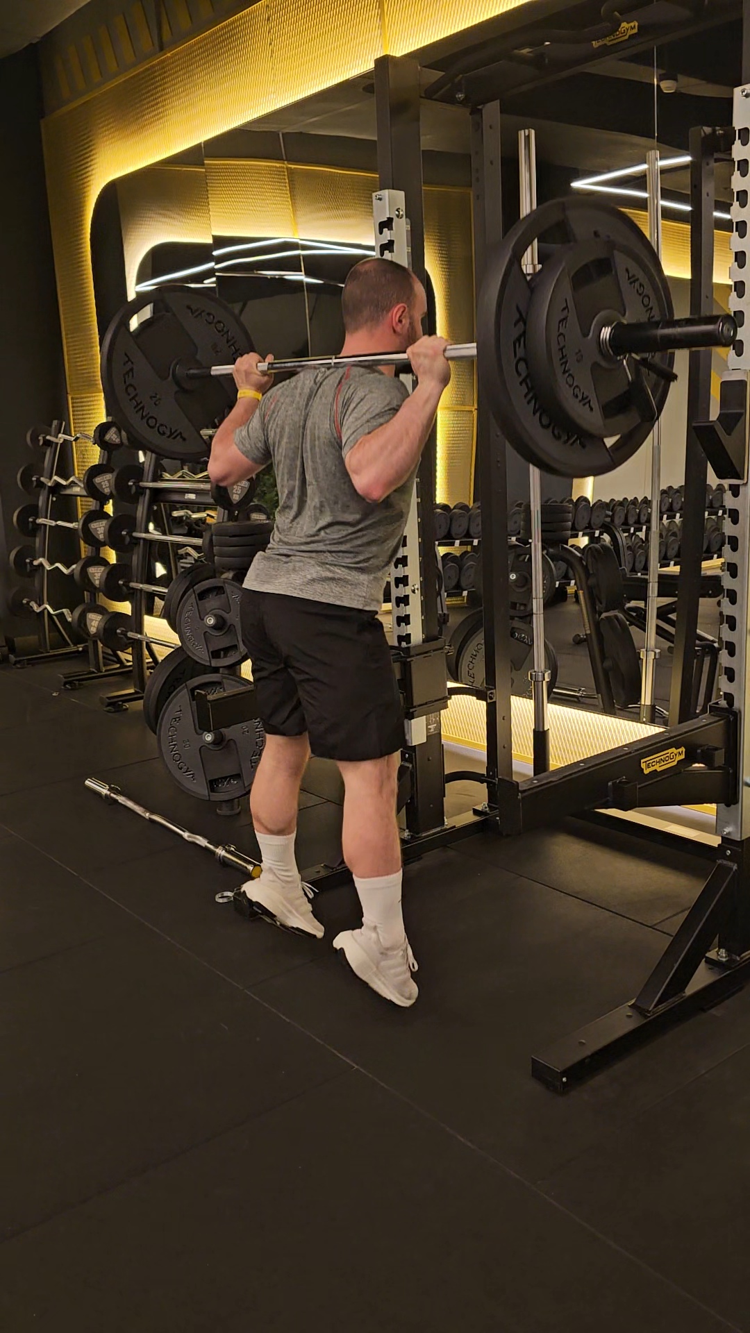 Trainer performing a back squat under the bar
